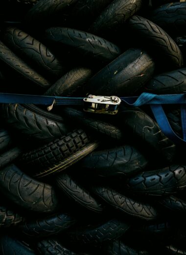 A pile of used tires strapped with a blue belt. Industrial and recycling theme.